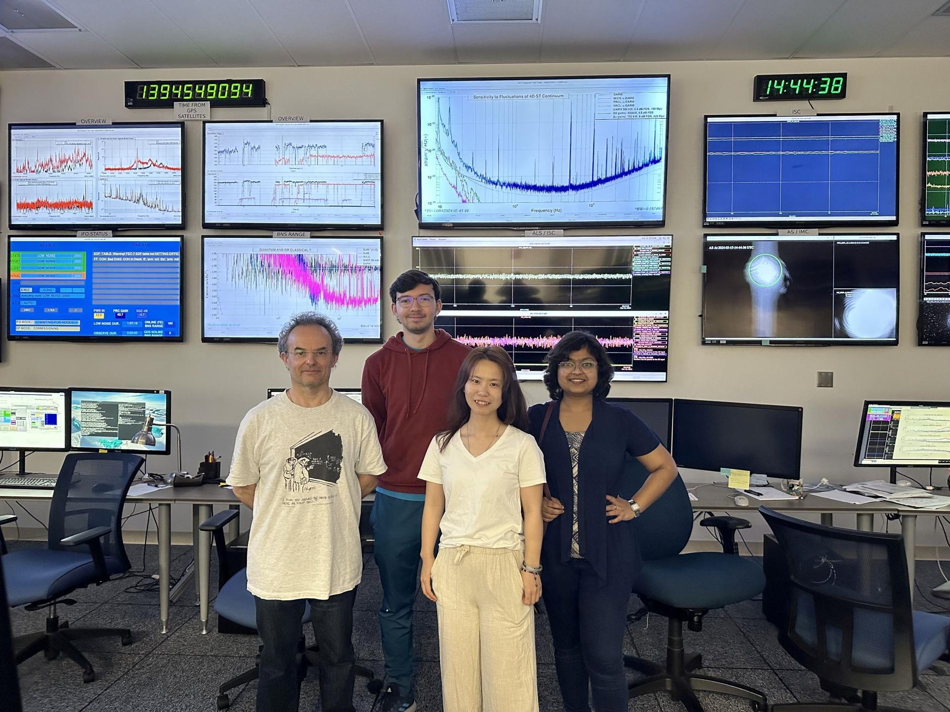 The LIGO team poses in front of computers. 