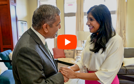 Chancellor Mo Dehghani shakes hands and smiles with Aruna Miller