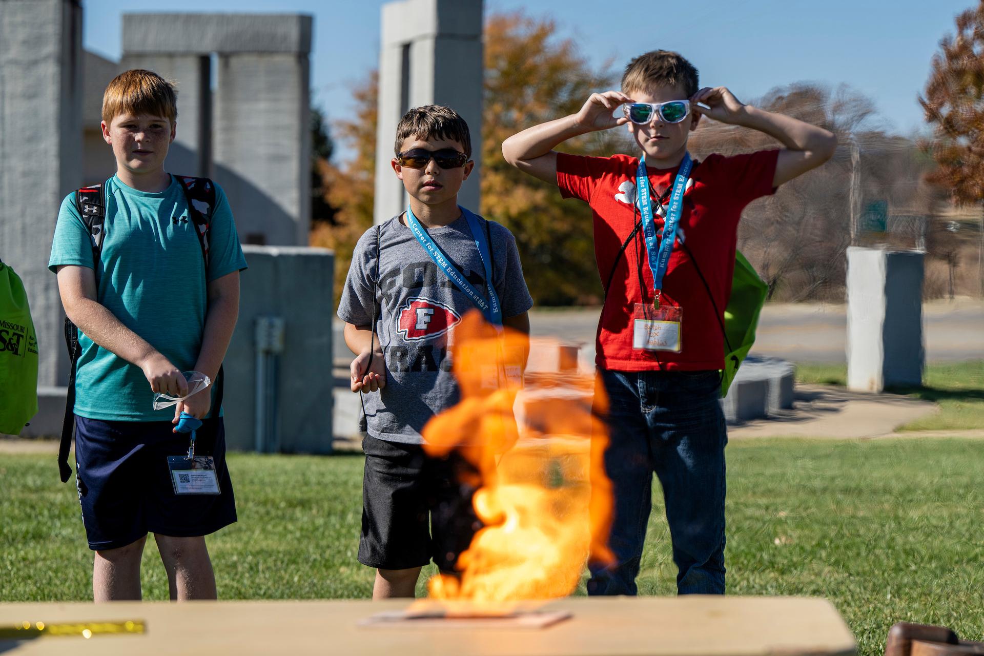 Young students watch a science experiment.