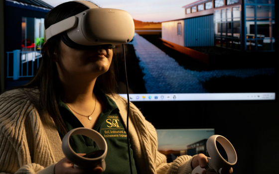 Mel Azimzadeh, a master’s student in civil engineering, uses an Oculus Quest 2 headset to tour the Missouri S&T Solar Village, shown behind her. Photo by Michael Pierce/Missouri S&T. 