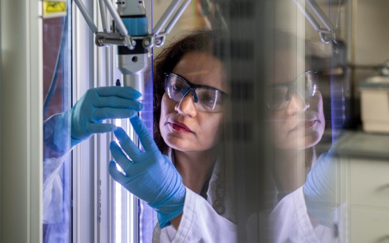 Photo of Dr. Fateme Rezaei experimenting with a 3D printing laboratory machine 