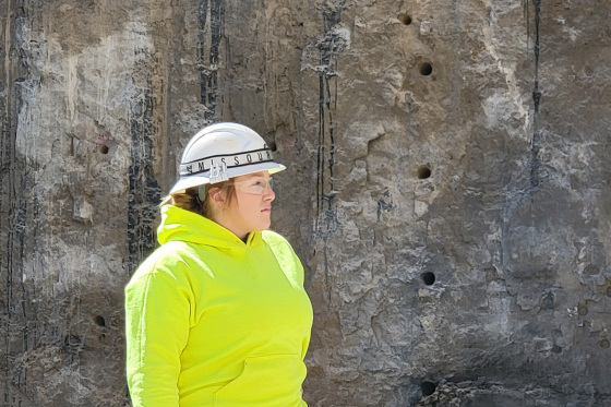 Photo of Ashley Davis wearing a hard hat at a mining site
